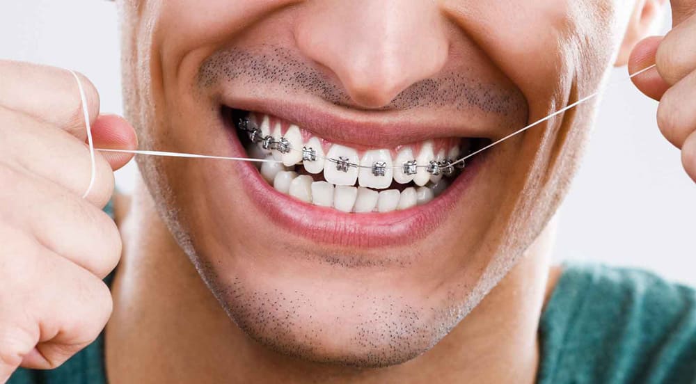 hombre usando hilo dental